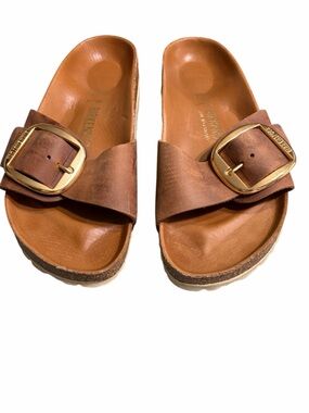 Birkenstock’s Brown Leather Slide Sandals with Gold Buckles